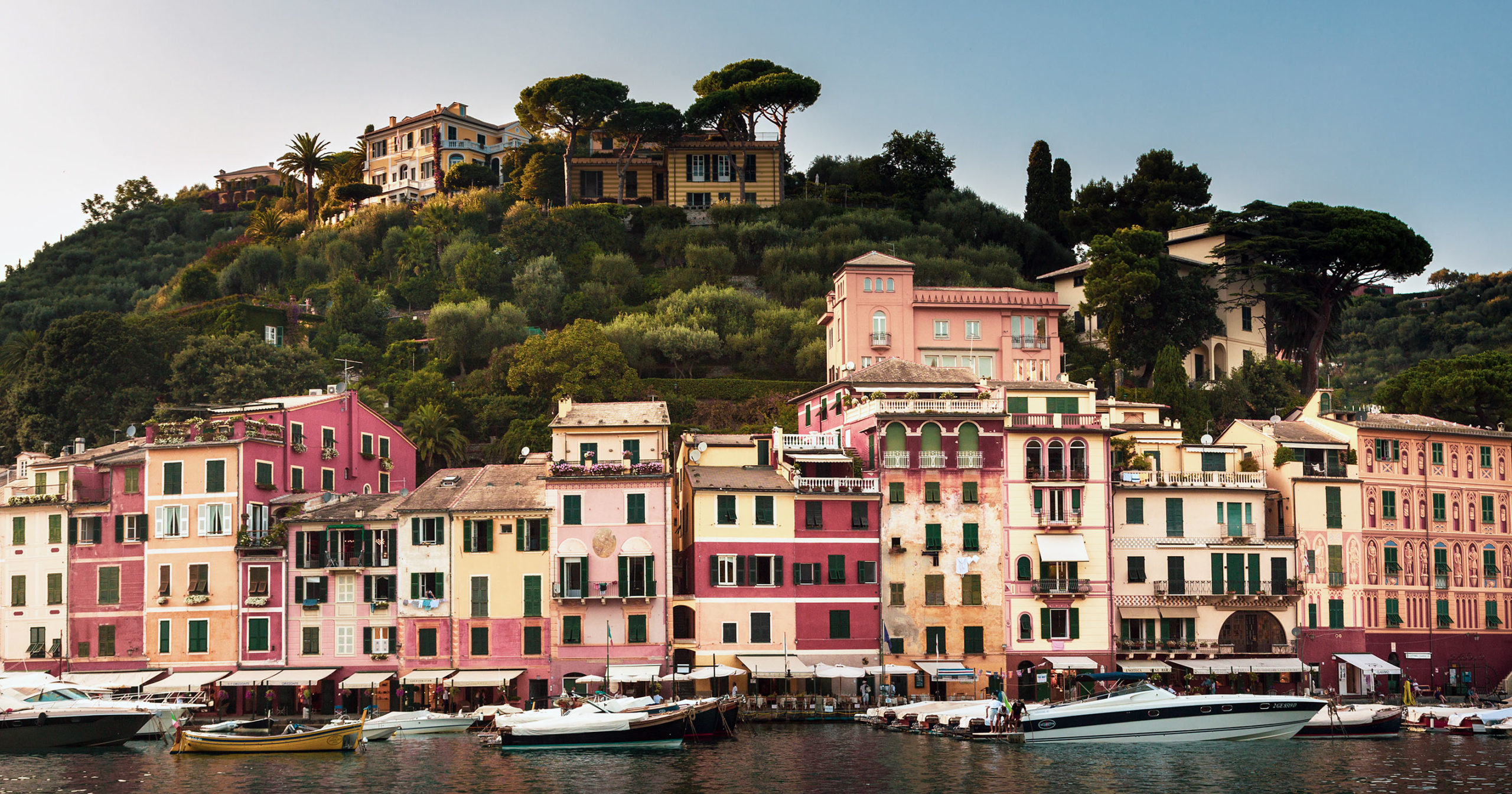 Portofino is a fishing village on the Italian Riviera coastline, southeast of Genoa city. Pastel-colored houses, border its piazza, a small cobbled square overlooking the harbor, which is lined with super-yachts.